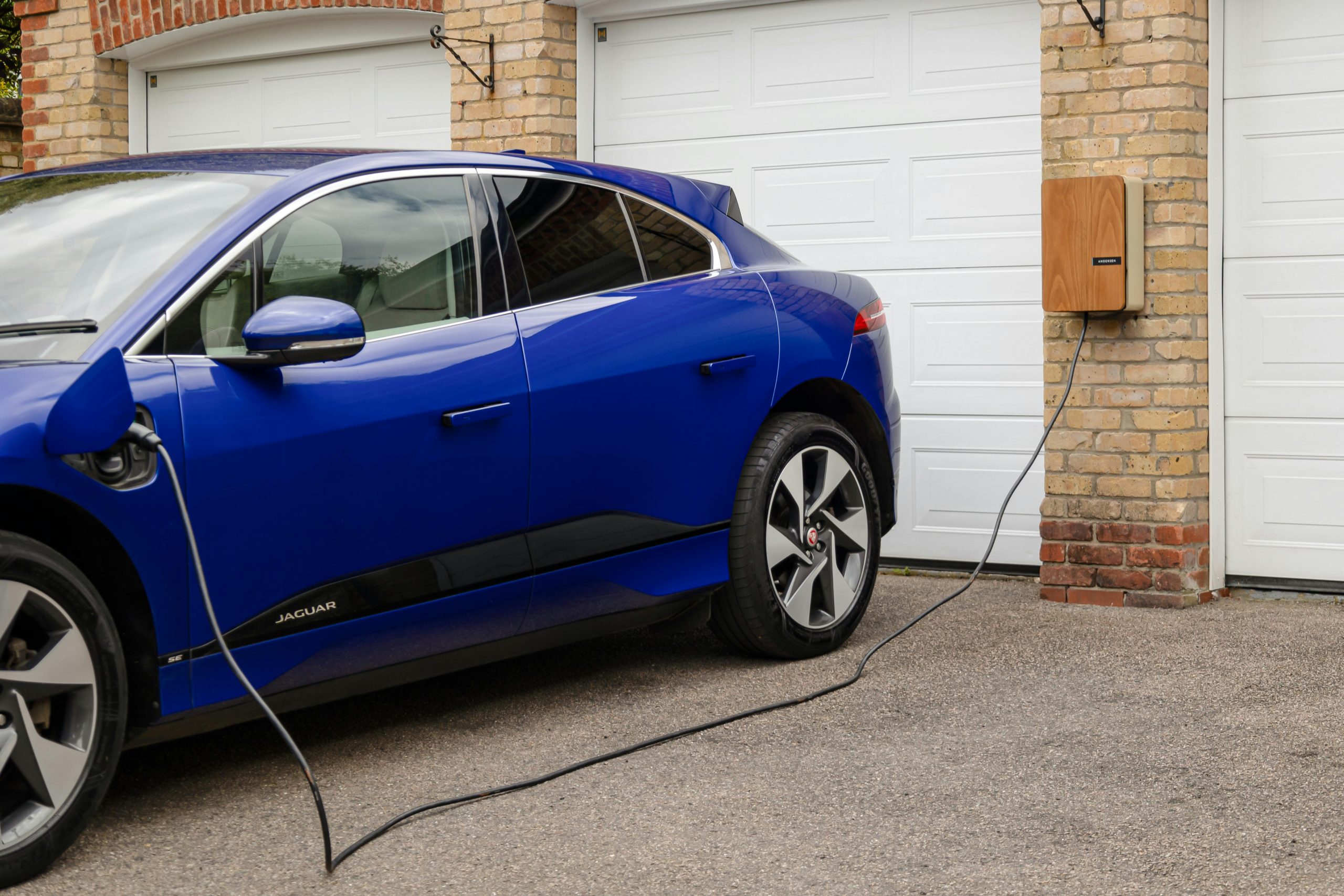 Coche eléctrico cargandose en garaje